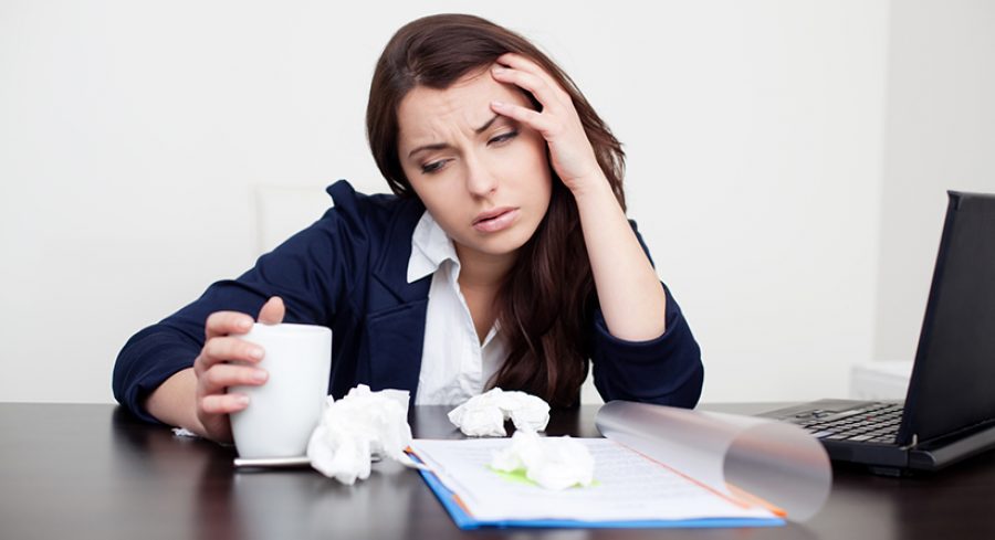Sick woman at work drinking coffee