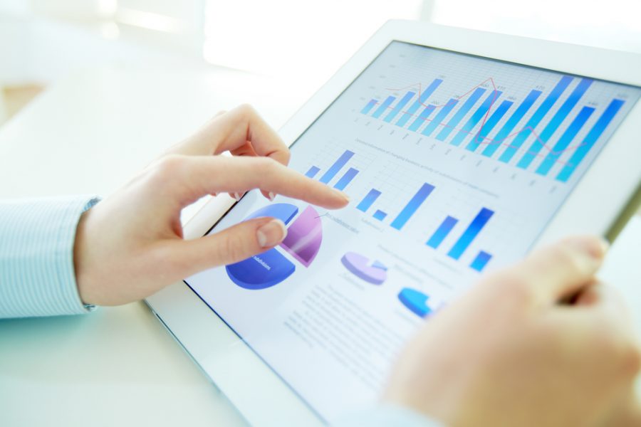 Close-up image of an office worker using a touchpad to analyze statistical data