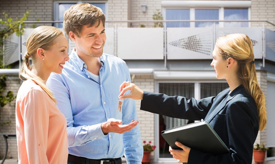 Real Estate Agent Giving House Key To Couple