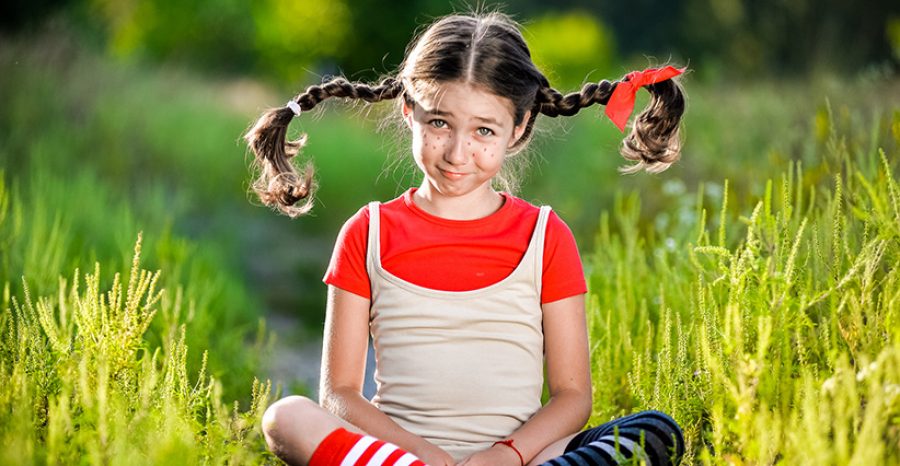 girl with pigtails imagines the summer on the nature