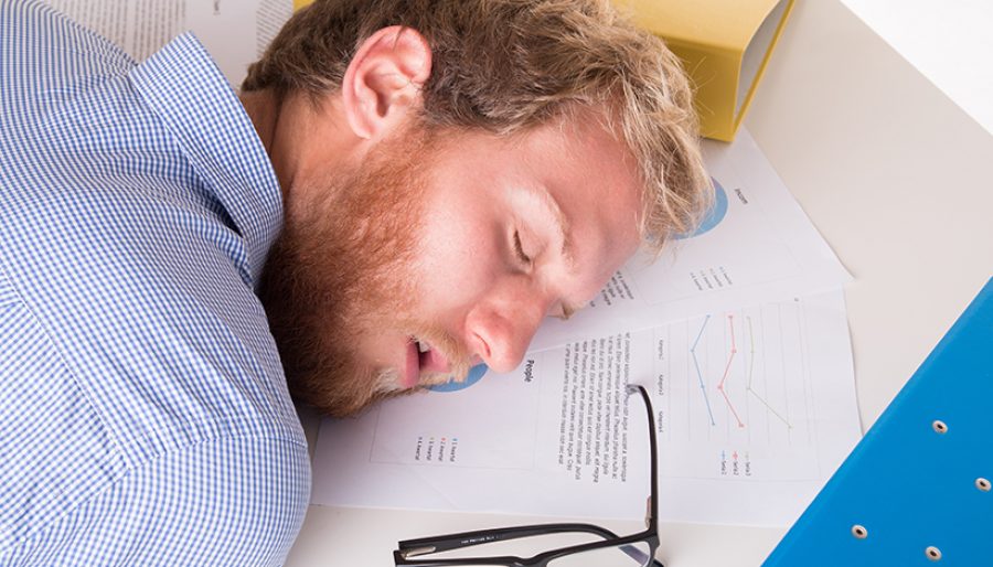 Worker sleeping on the desk in the office
