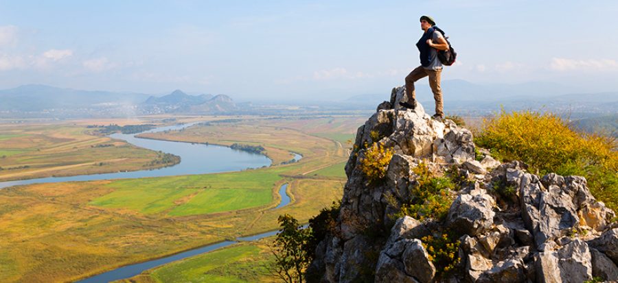 Hiker man climbed a mountain and admire nature