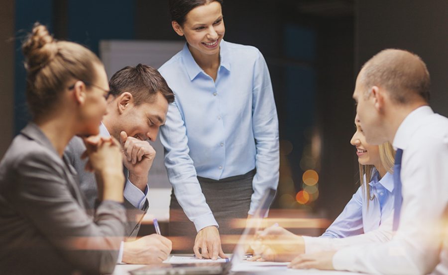 smiling female boss talking to business team
