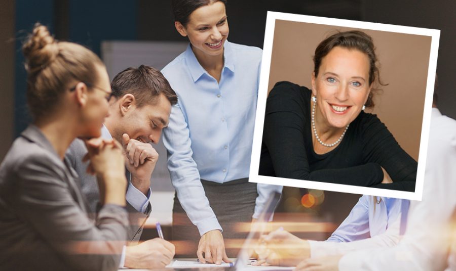 smiling female boss talking to business team