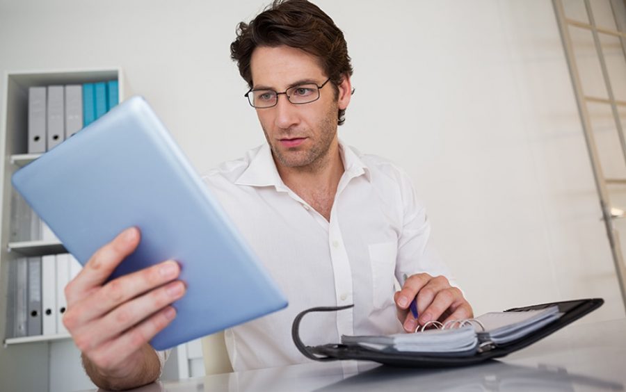 Casual businessman organizing his schedule at his desk in his office