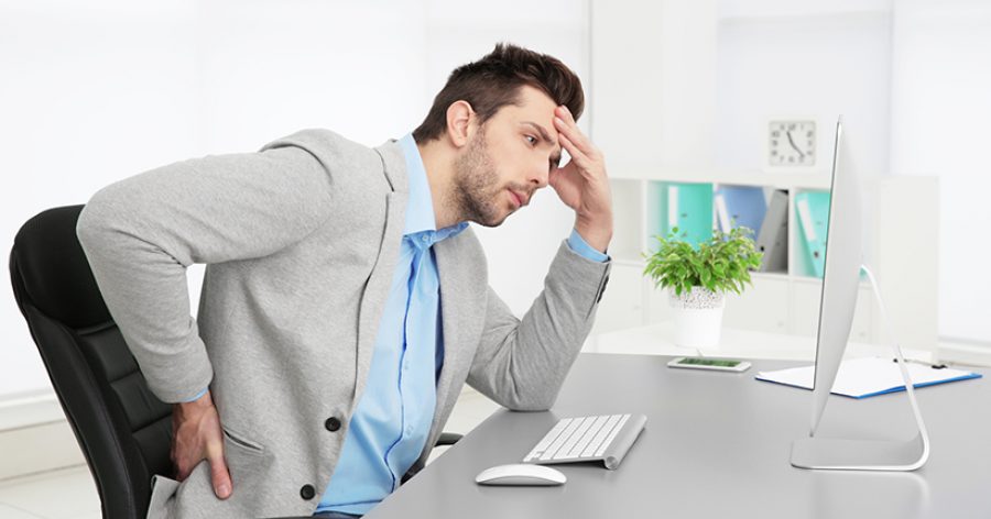 Incorrect posture concept. Man sitting at office table