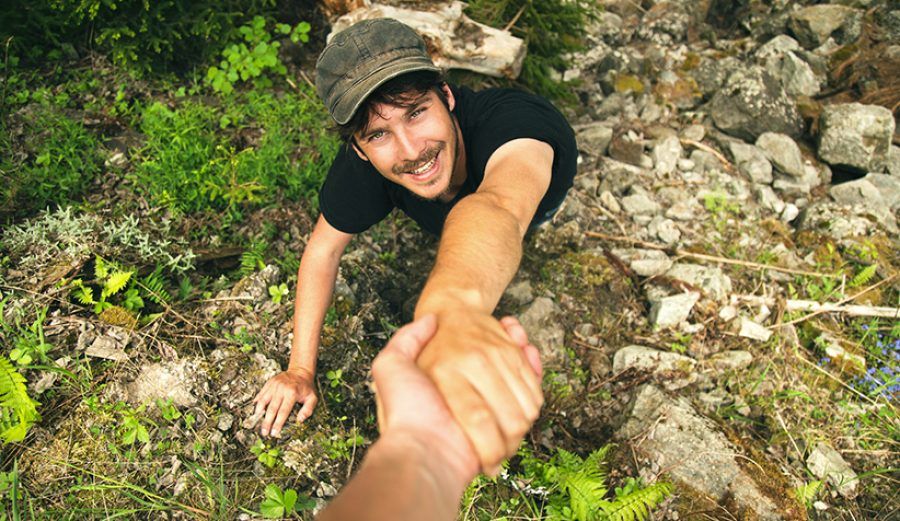 Climbers helping each other to climb the mountain