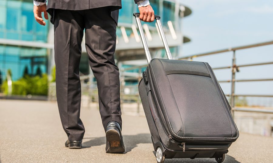 Ready to business trip. Rear view of businessman in formalwear c