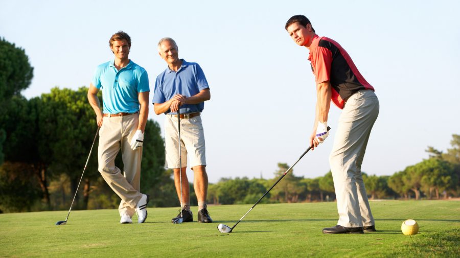 Group Of Male Golfers Teeing Off On Golf Course