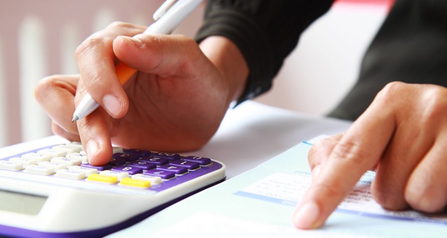 Woman's hands with a calculator and a pen