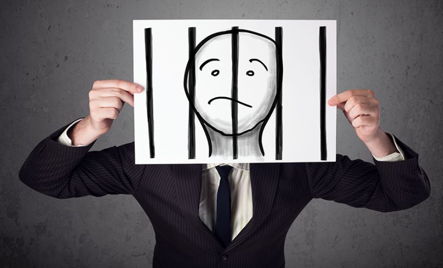 Businessman holding a paper with a prisoner behind the bars on i