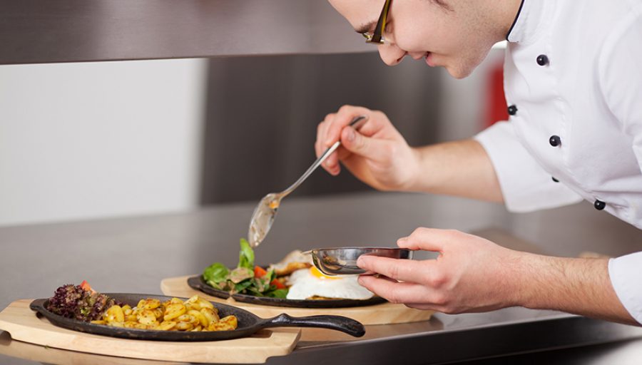 Chef Garnishing Egg Dish With Sauce In Kitchen