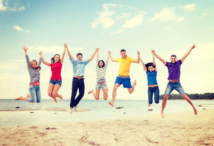 group of friends jumping on the beach