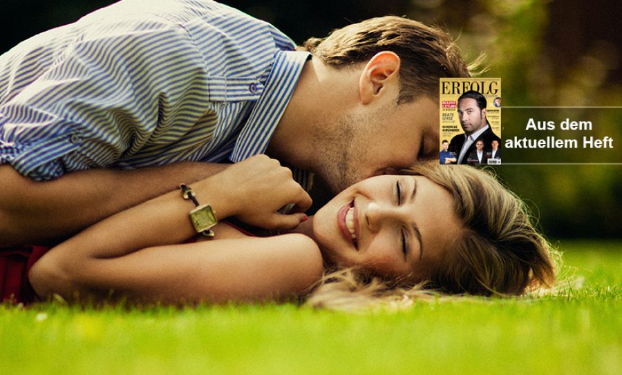 Young beautiful couple lie on the lawn