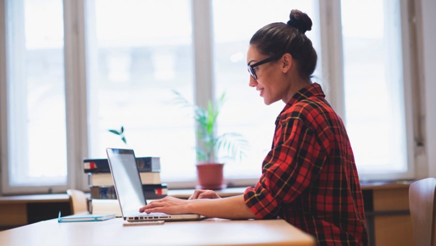 Young hipster girl working on laptop