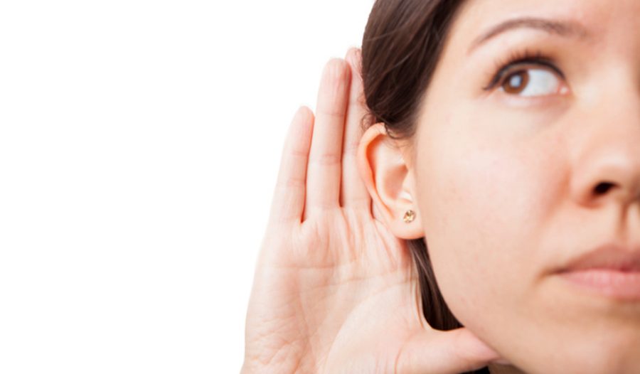 Woman holds her hand near ear and listens carefully